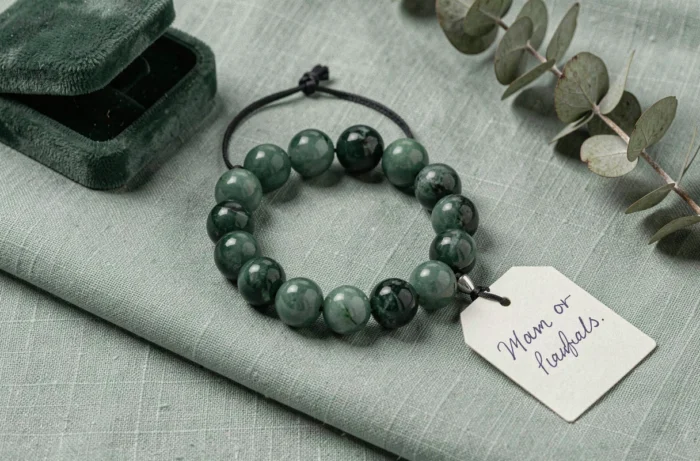 Bracelet homme en jade vert foncé poli sur un tissu lin avec écrin et étiquette cadeau